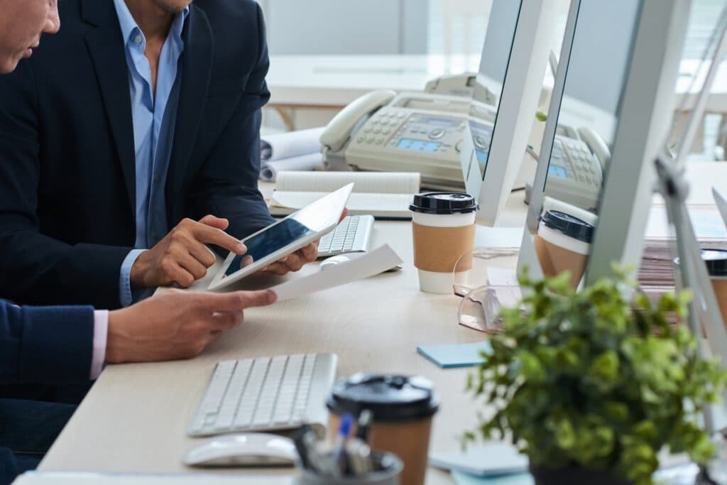 Hommes d'affaires consultant un document sur tablette
